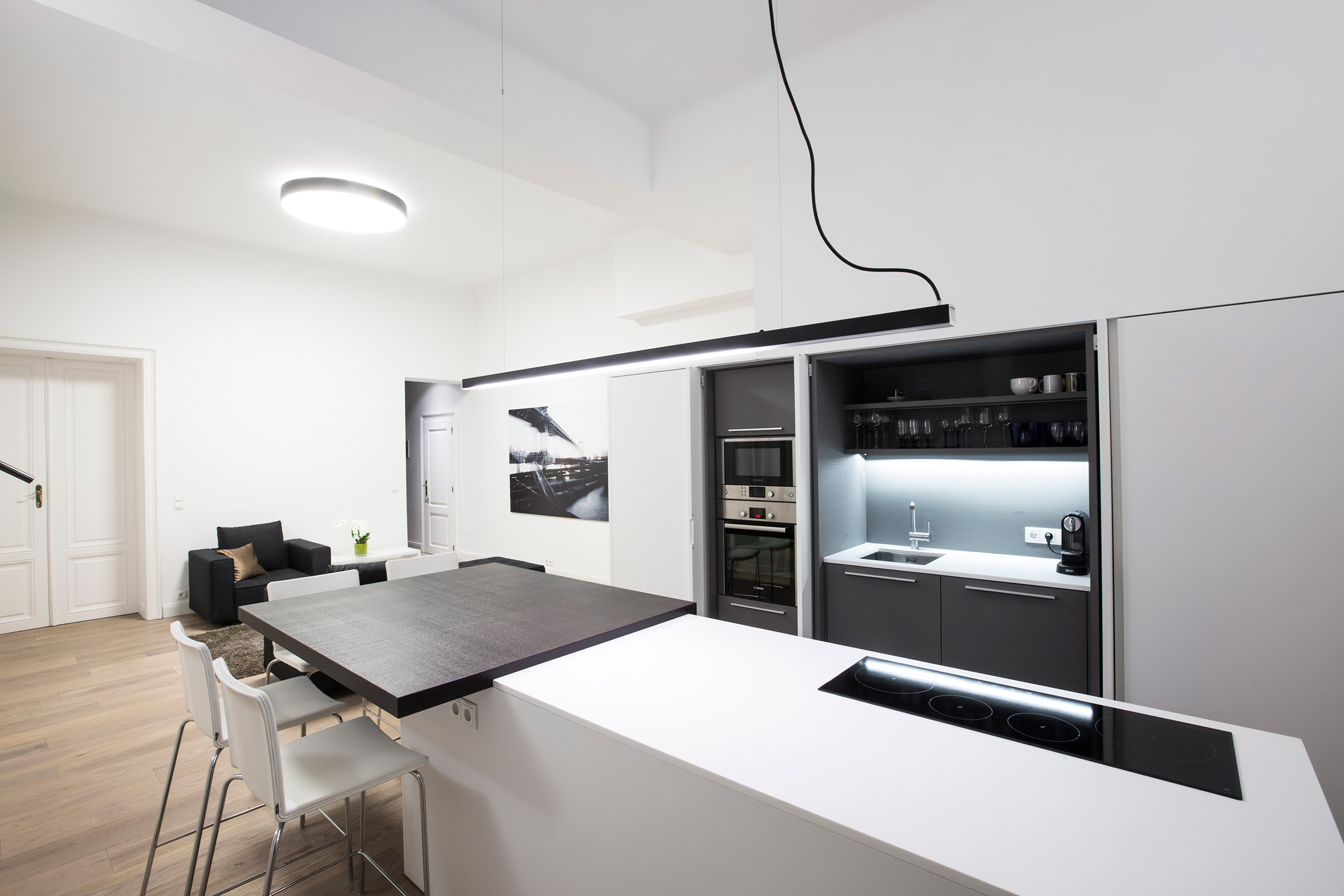 Kitchen bar with white island, induction hob and bar seating